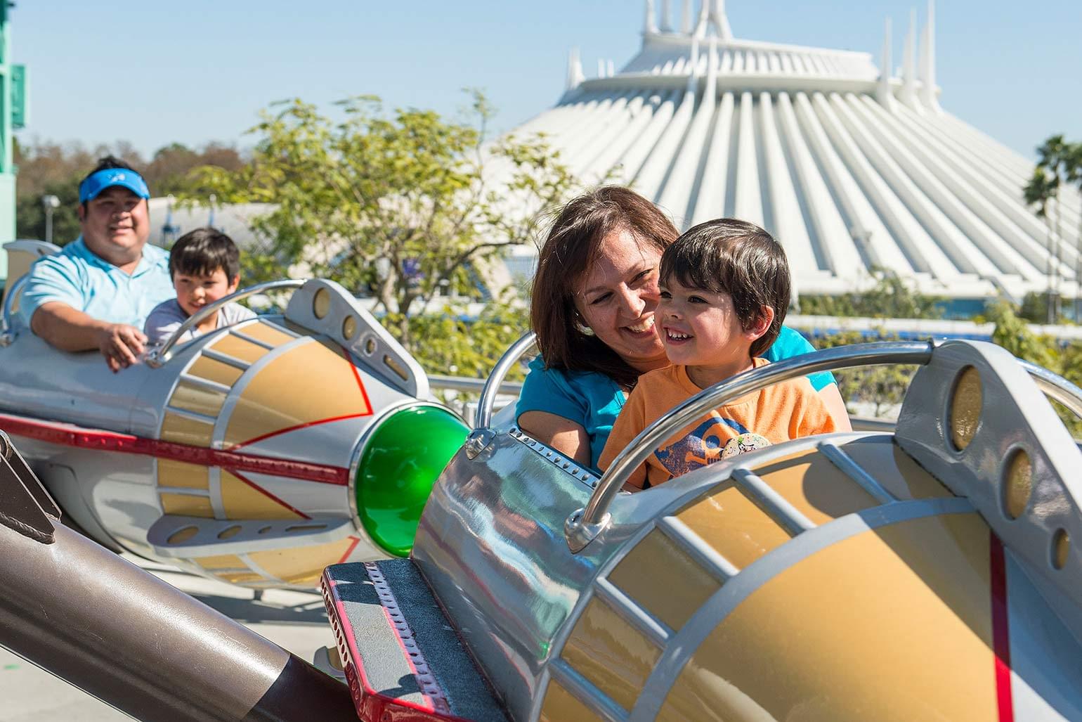 Smiling family enjoys the Astro Orbitor ride in Tomorrowland.