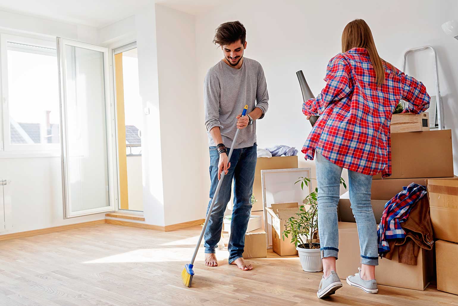 First time home buying couple cleaning their new condo before unpacking their moving boxes