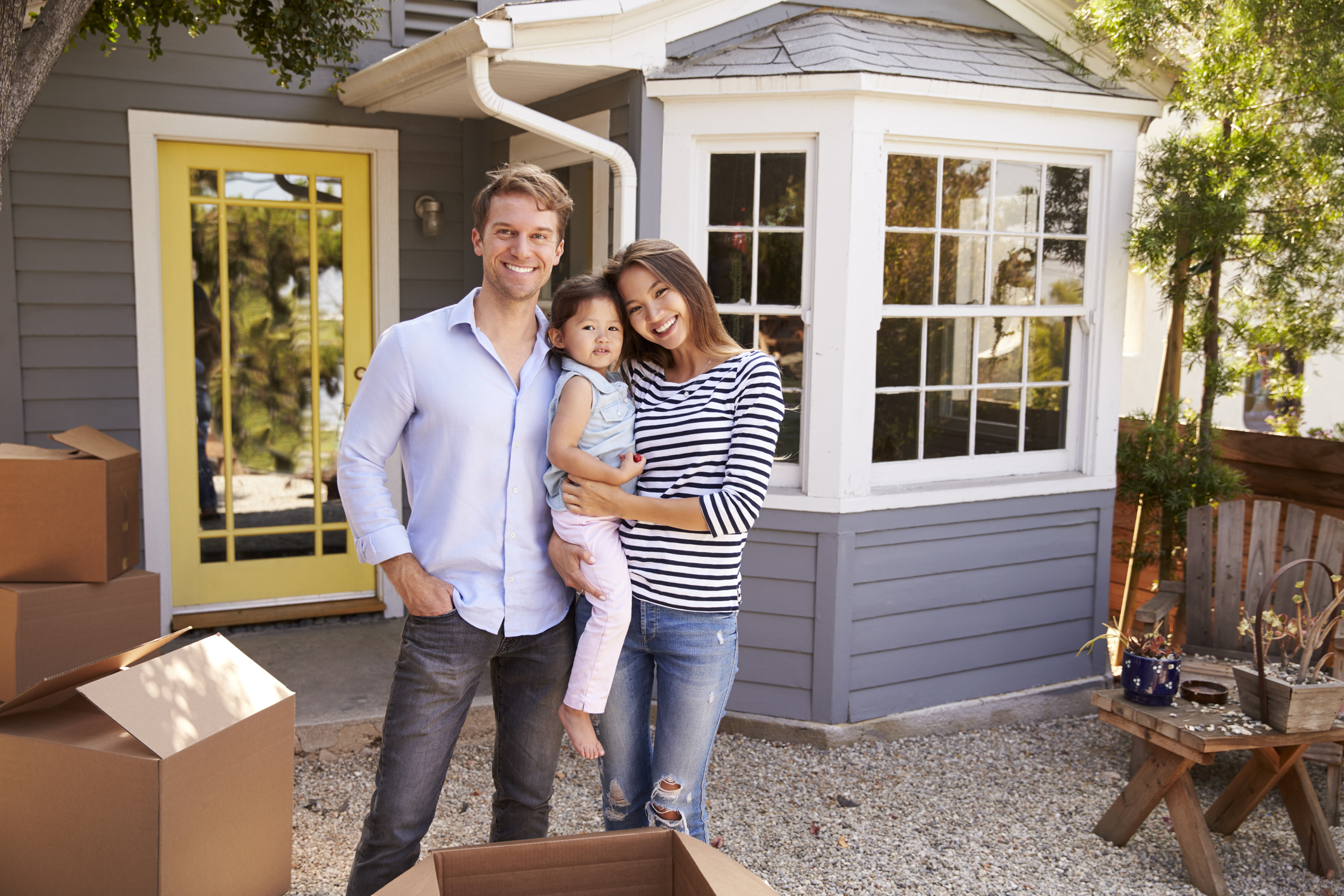 Portrait Of Excited Family Standing Outside New Home