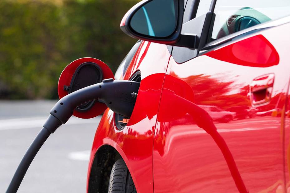 A red car getting gas pumped.