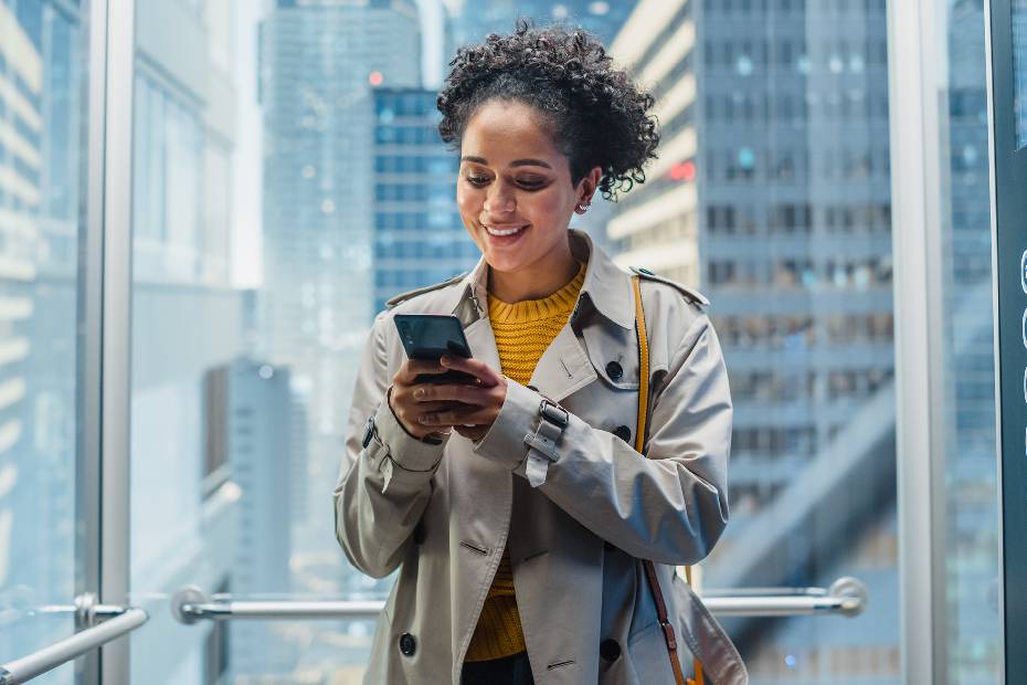 A woman checks her phone in an elevator.