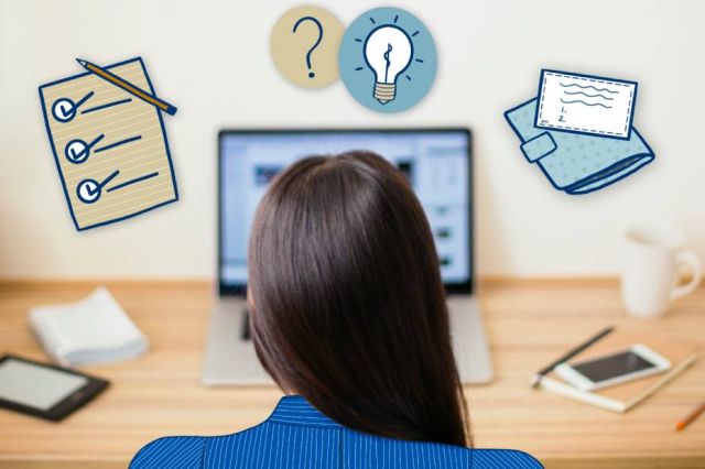 Woman at a desk looking at laptop.