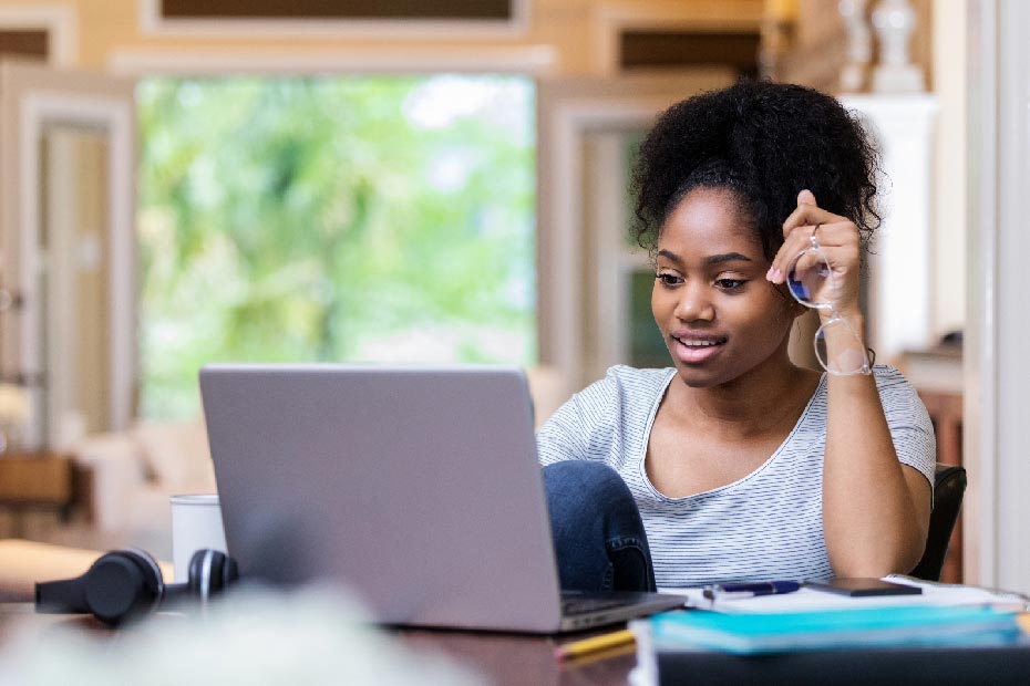 A post-secondary Canadian female student on her laptop looking for ways and options to pay for school — college or university — in Canada.