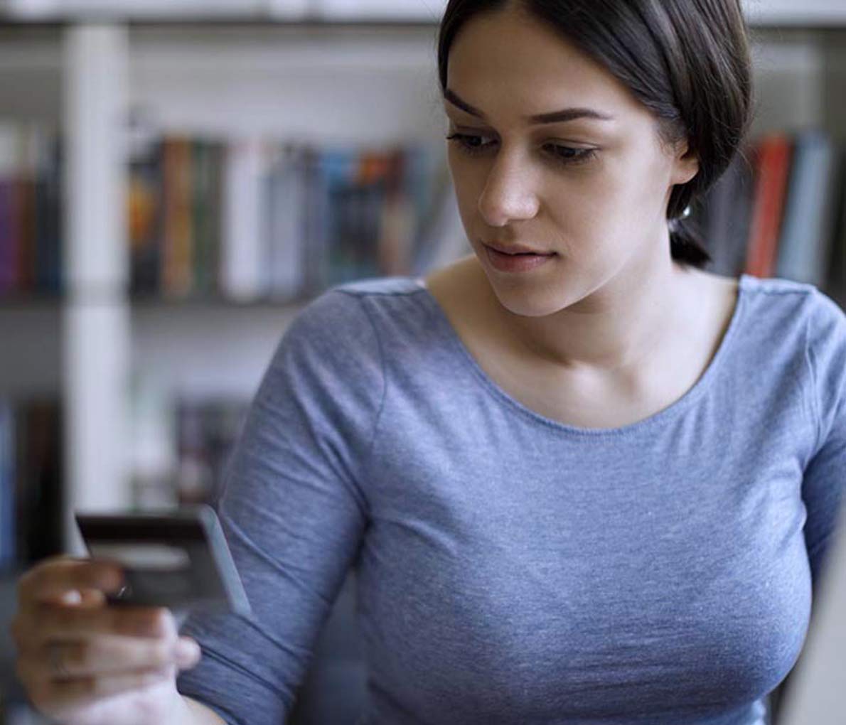 Image showing a young woman paying bills with a credit card