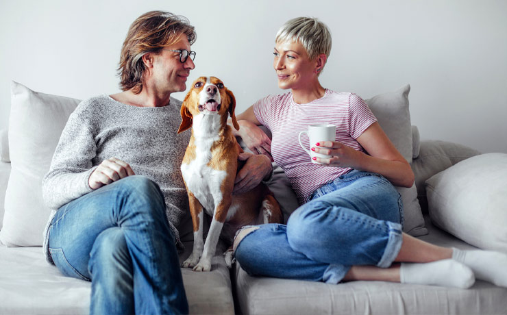 Couple sitting on couch with their dog