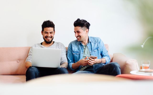 Friends sitting on couch with devices