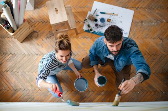 A couple painting a wall together