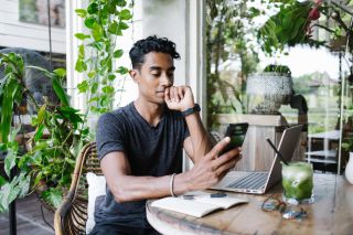 A curious investor reads about economic terms on a mobile phone.