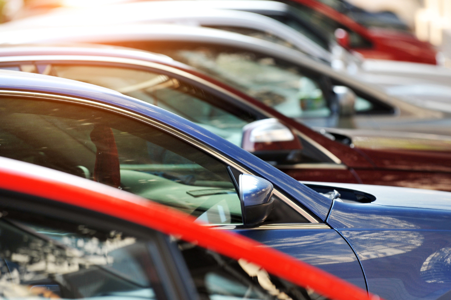 A group of cars in various colours parked in a row