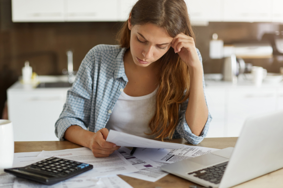 Woman at a desk, stressed about her finances