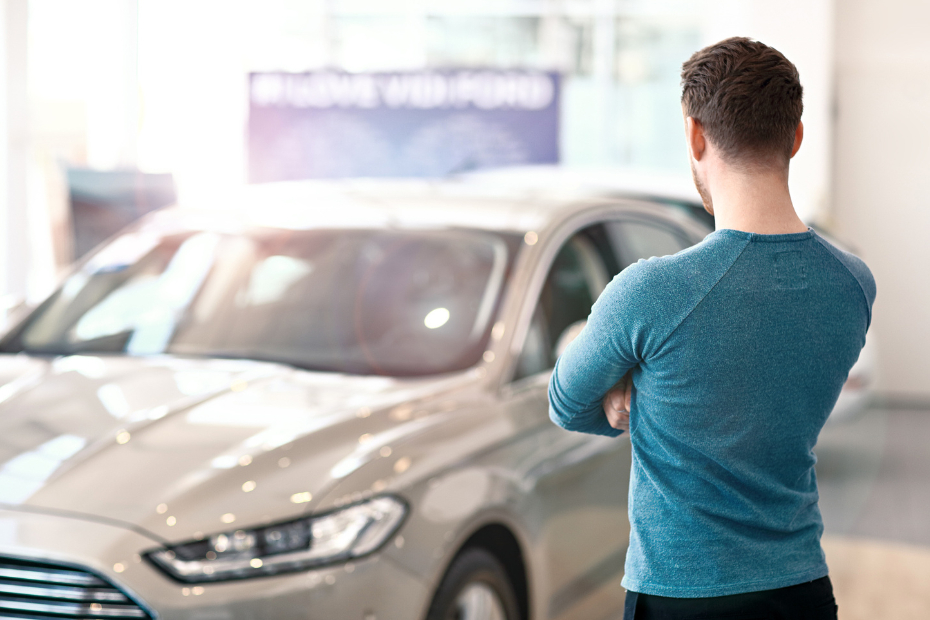 Young man looking at the new car