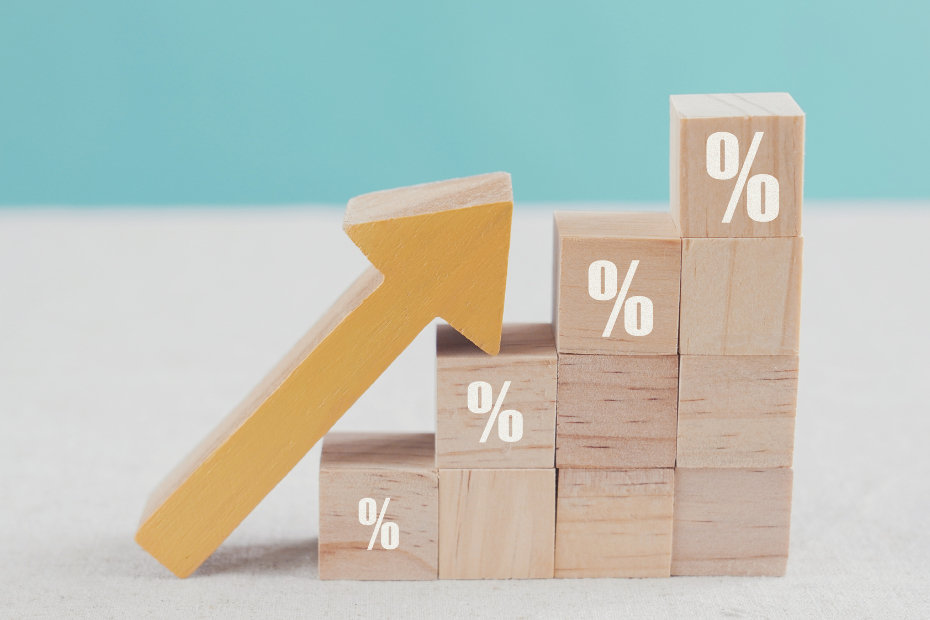 Wooden cut outs of a % sign, a house and an arrow pointing up in red.