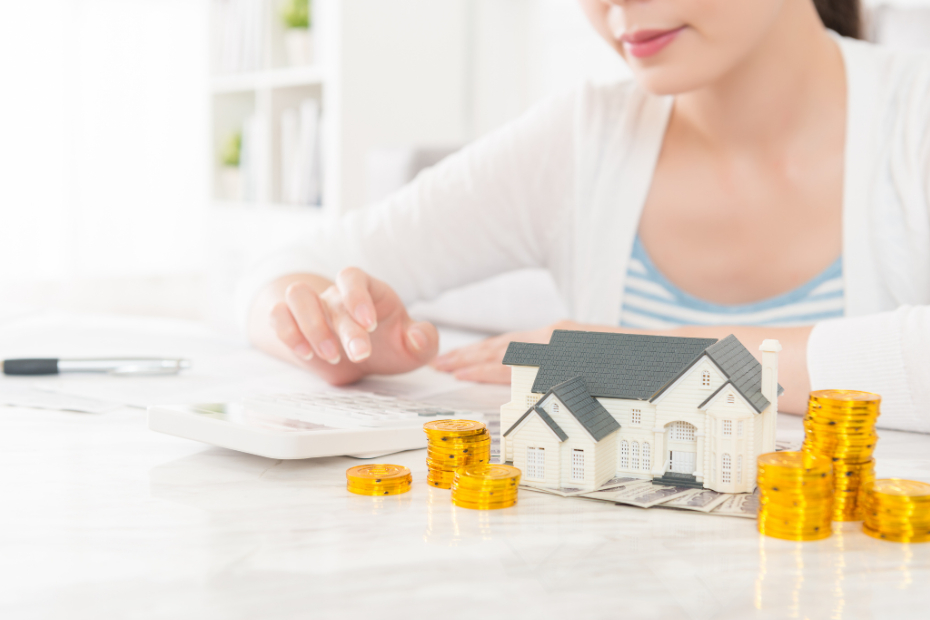 Woman stacking coins on a house