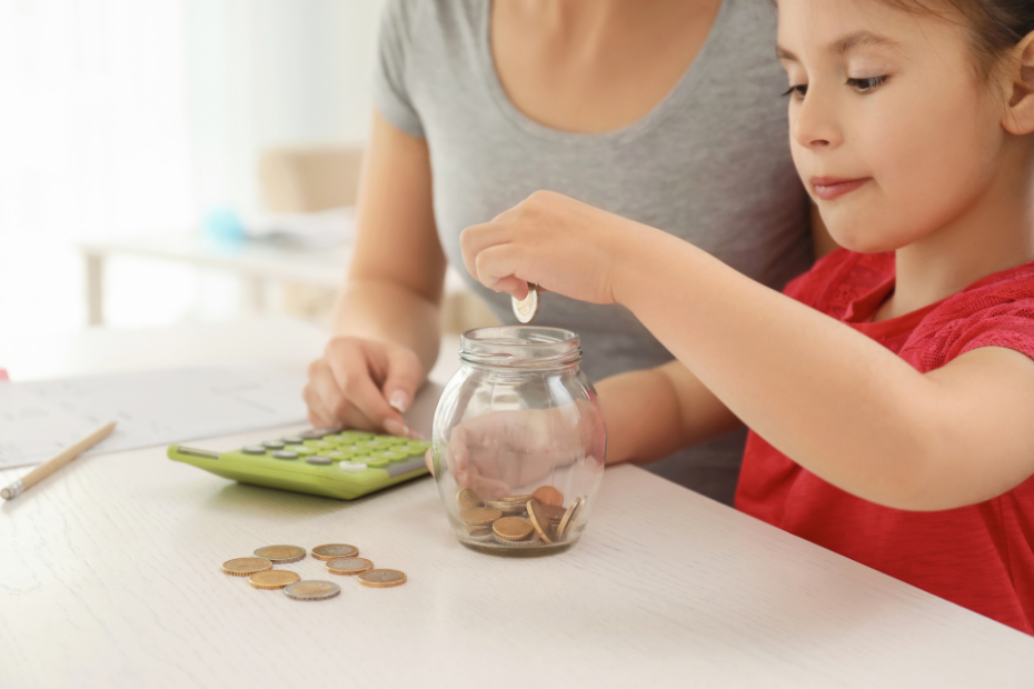 Young girl with her mother at table counting money.