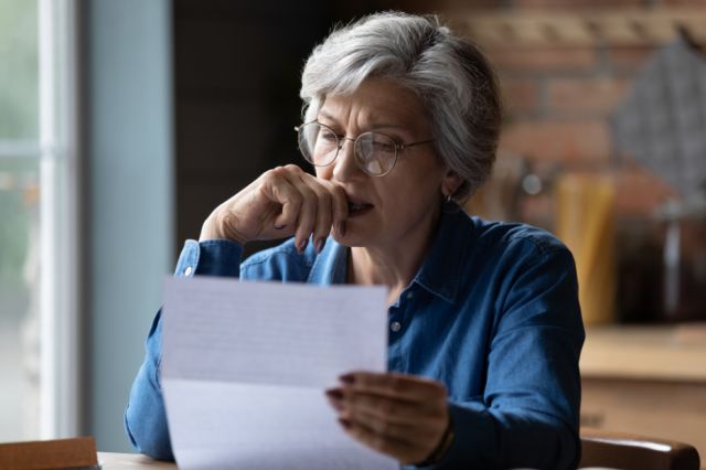 A middle-aged woman looking at a financial statement