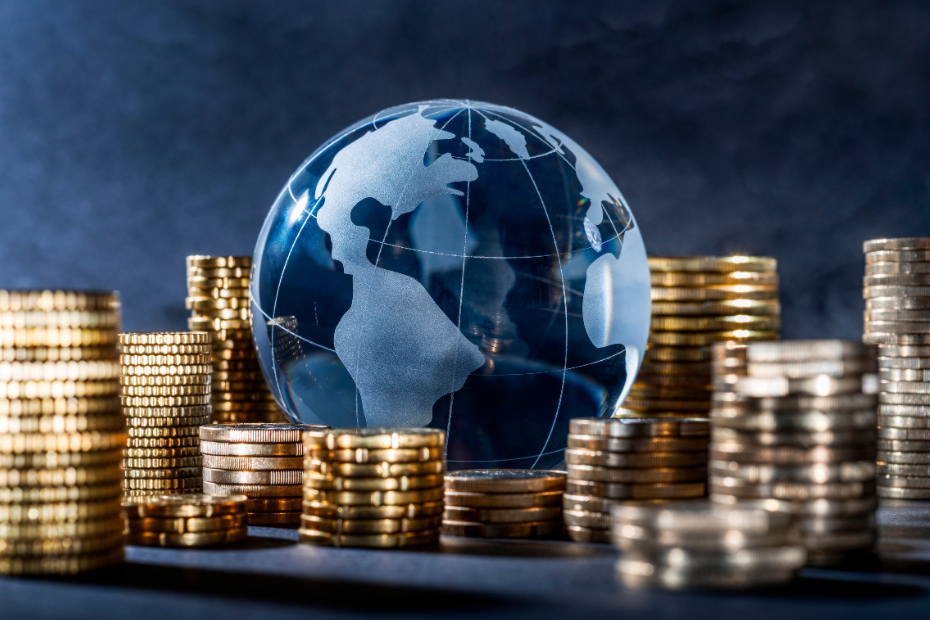 Glass globe surrounded by a stack with coins.