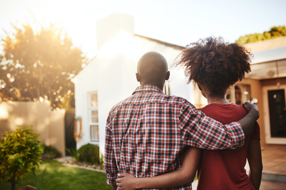 Two people look at a house.