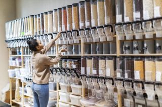 Une jeune cliente a rempli un contenant de haricots secs dans une coopérative.