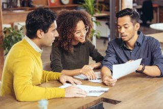 3 personnes regardant des documents