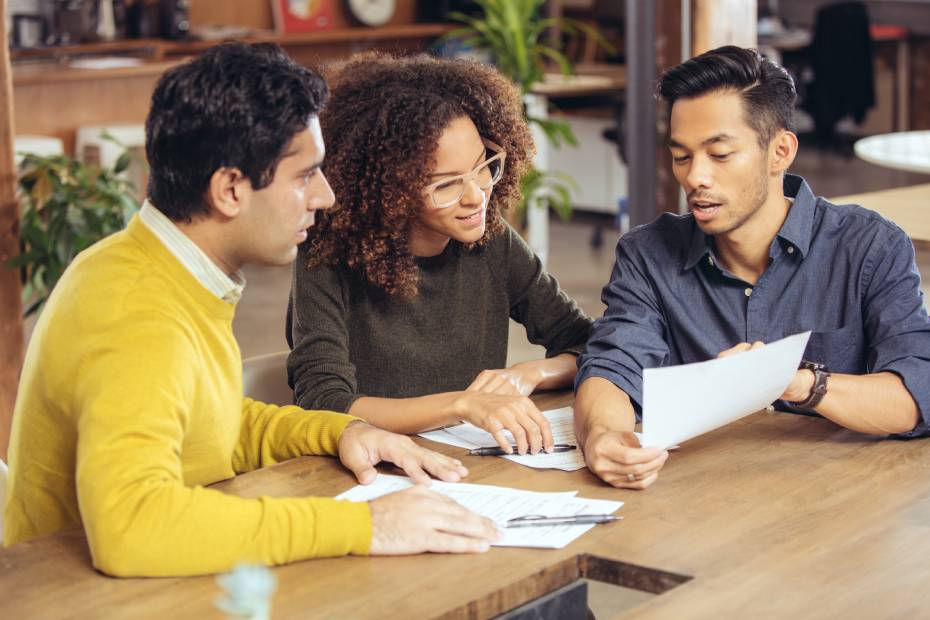 3 personnes regardant des documents