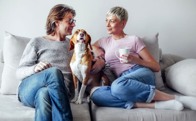 Couple assis sur le canapé avec leur chien