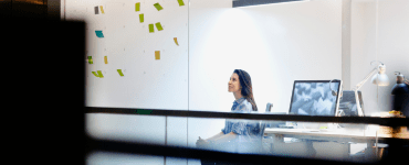 Femme dans un bureau regardant des notes autocollantes