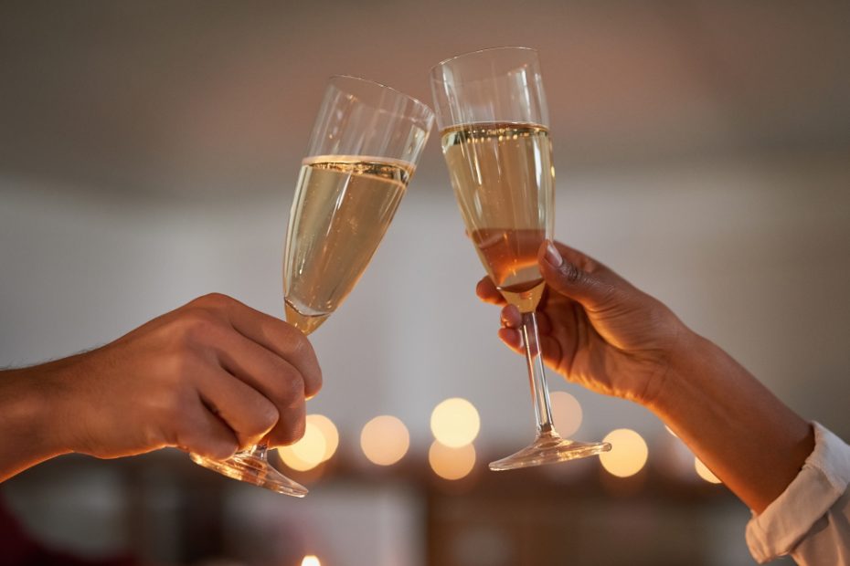 Mains d'un couple qui lève leur flûte de champagne