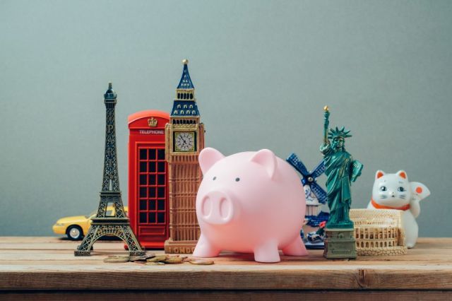 Table avec des figurines de Big Ben, de la tour Eiffel et de la statue de la liberté ainsi qu'une tirelire