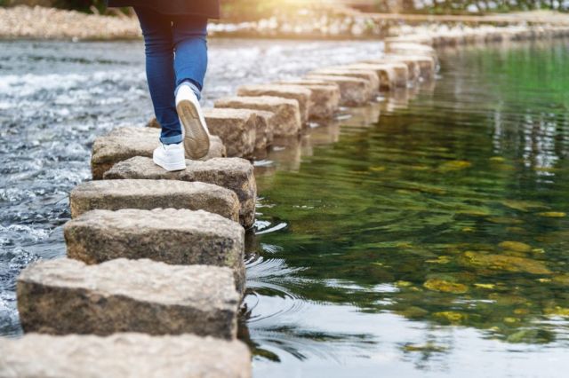 Personne traversant une rivière sur des tremplins