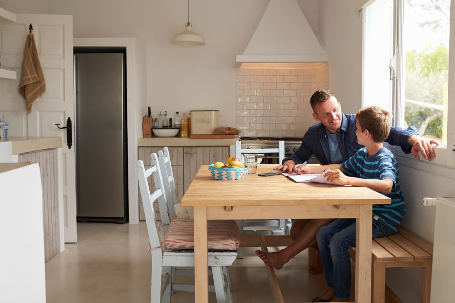 Père et fils assis dans leur cuisine nouvellement rénovée