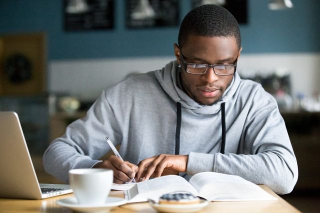 Un jeune Afro-Américain étudie à la bibliothèque de son université.