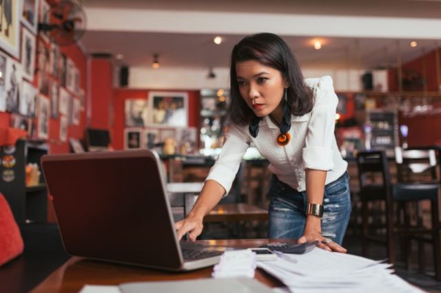 Entrepreneur stressé, appuyé sur un bureau et confronté à des difficultés financières.