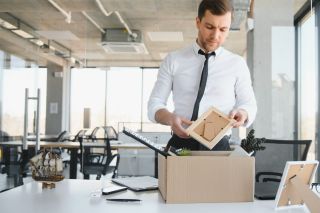 Un employé de bureau emballe ses affaires dans une boîte en carton.